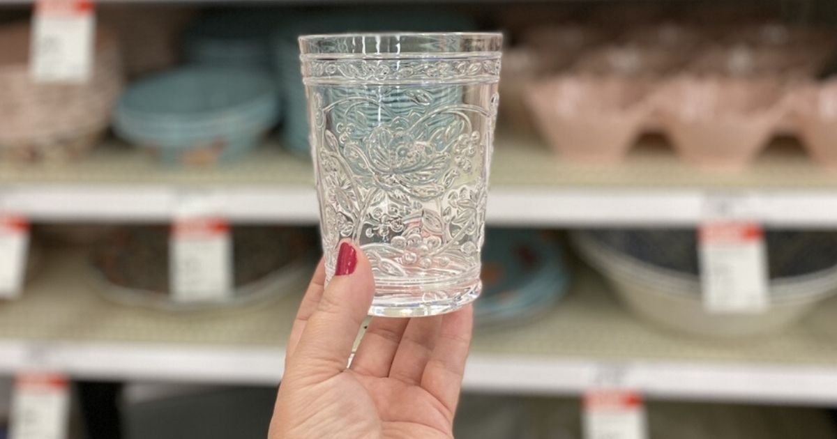 woman's hand holding a plastic floral embossed tumbler