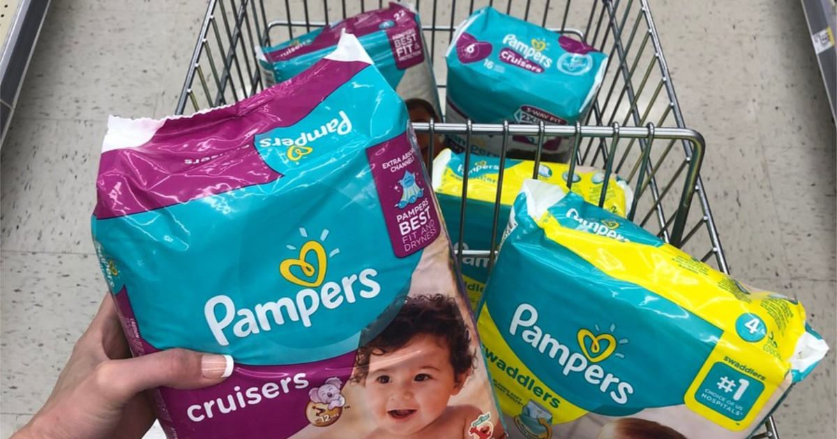 woman holding diaper package over cart of diapers in store