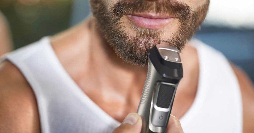 man using trimmer on beard
