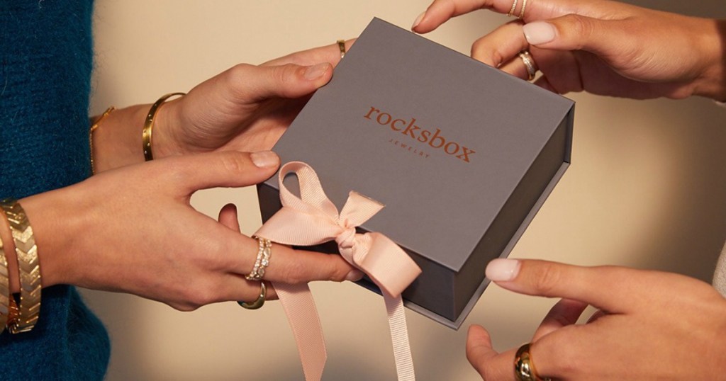 2 women holding Rocksbox Jewelry Subscription box with ribbon