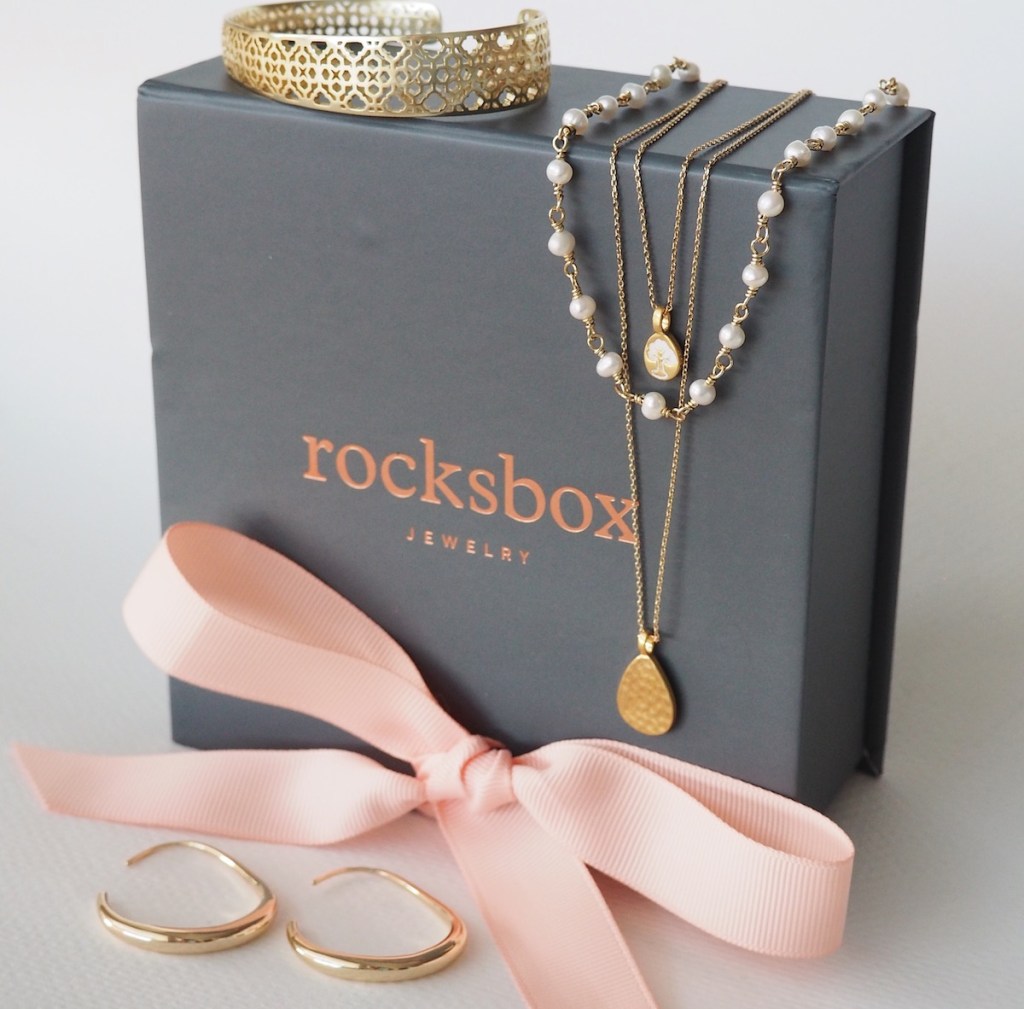 jewelry sitting on a box with a bow next to it