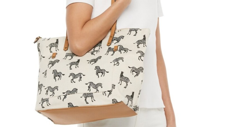 woman holding a large handbag with zebras printed on it