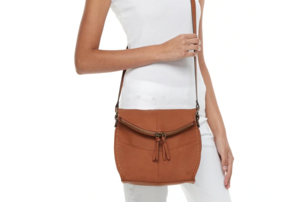 woman holding a tan purse