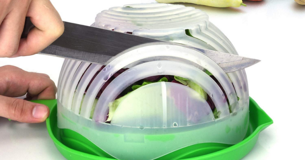hand cutting salad with knife in salad cutter bowl