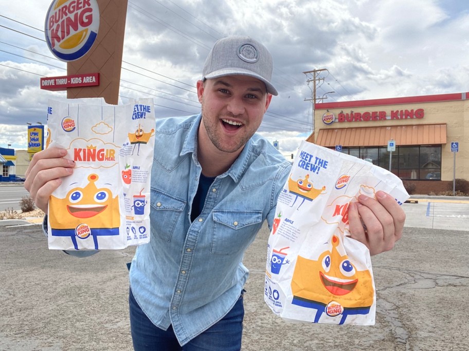 man holding 2 bk kids meals
