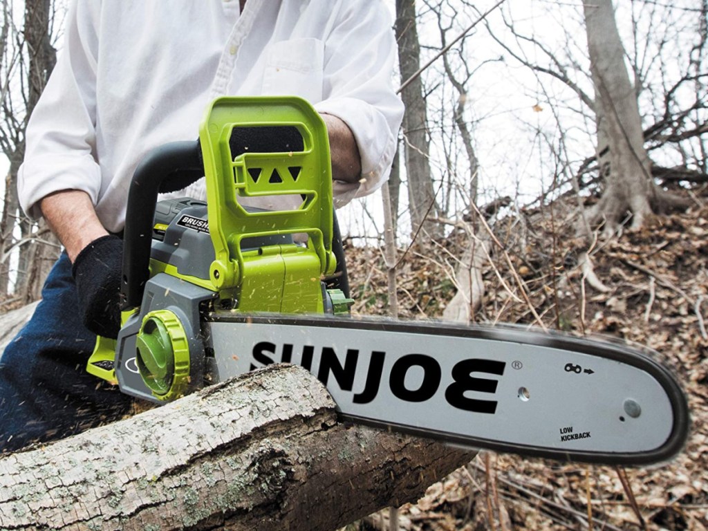 man using chain saw to cut tree branch