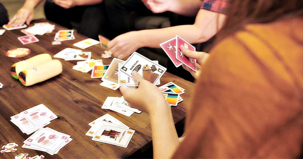 Throw Throw Burrito by Exploding Kittens game being played by friends at coffee table