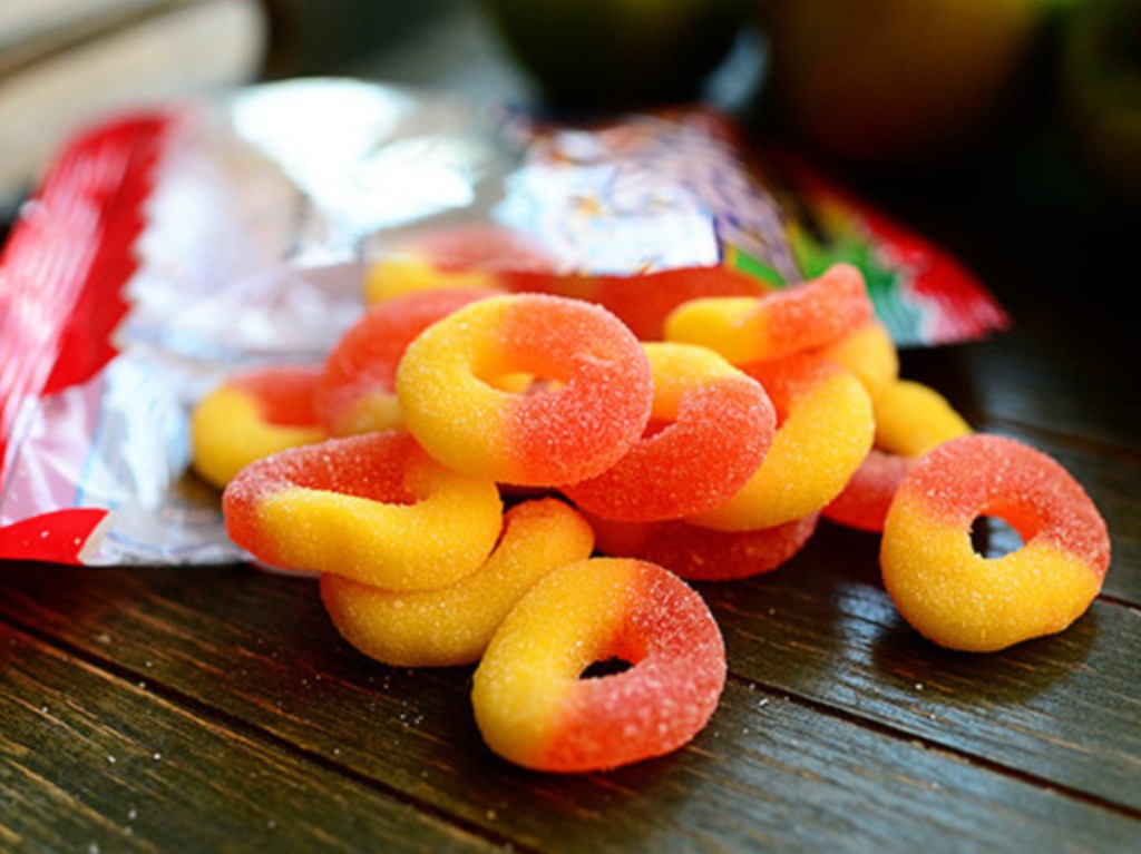 peach ring gummy candy spilling out of bag on table