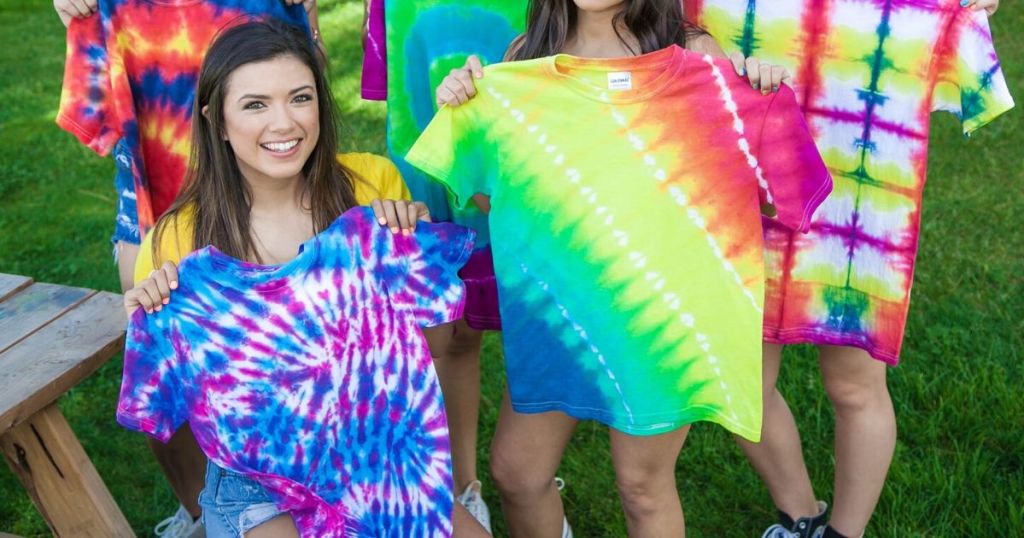 five girls holding up completed tie dye shirts 