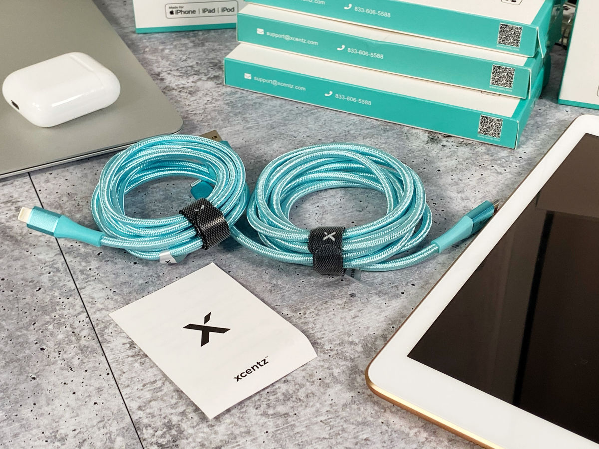 two Xcentz Iphone Cord Blue coiled up next to ipad with boxes