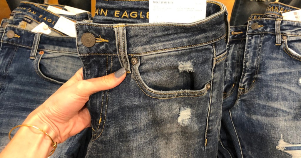 hand holding up american eagle jeans in store