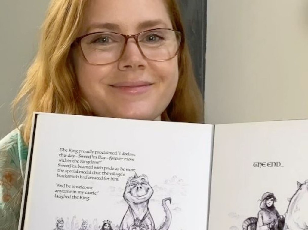 actress Amy Adams holding up a children's book