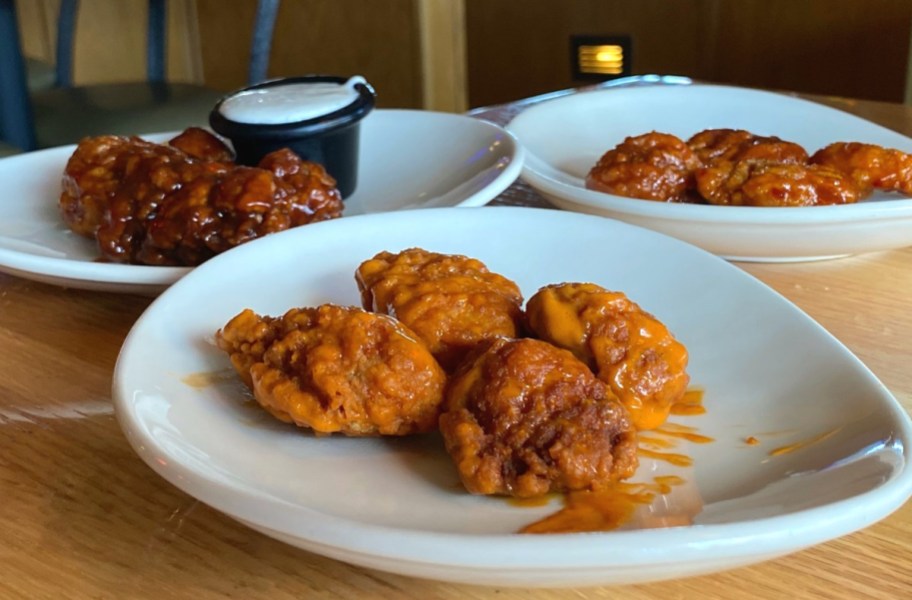 plates filled with boneless wings on a table