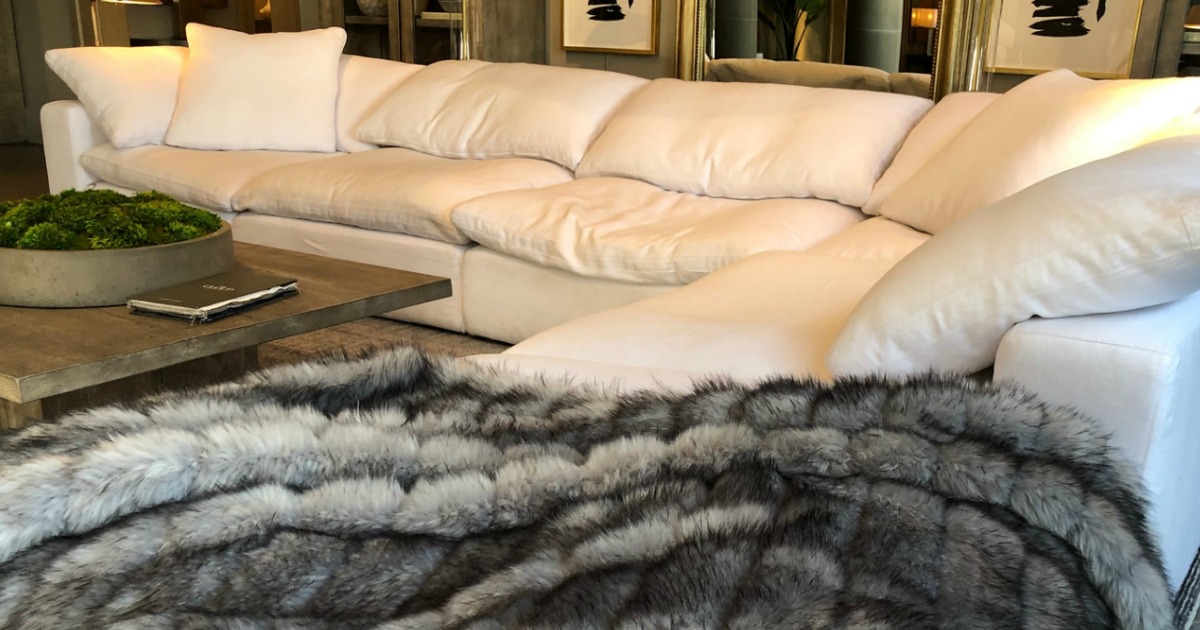 white cloud couch with blanket and coffee table 
