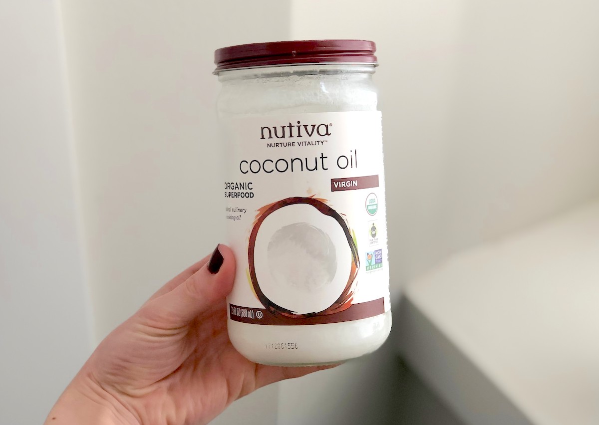 hand holding a jar of Nutiva coconut oil 