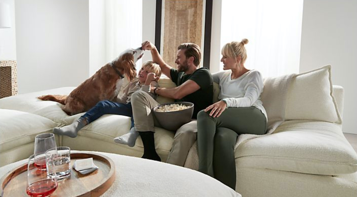 family and dog sitting on cream colored sectional