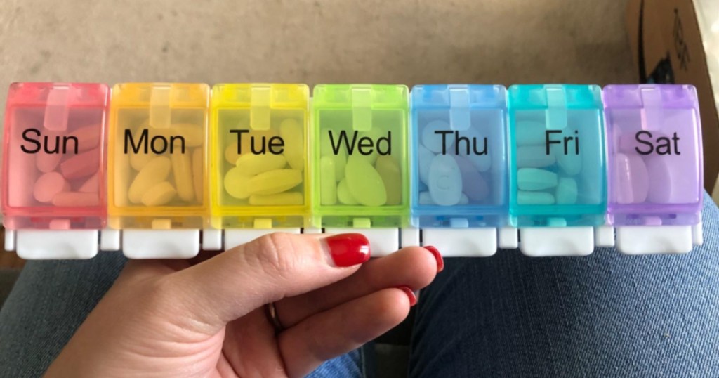 hand holding multi-color weekly pill organizer