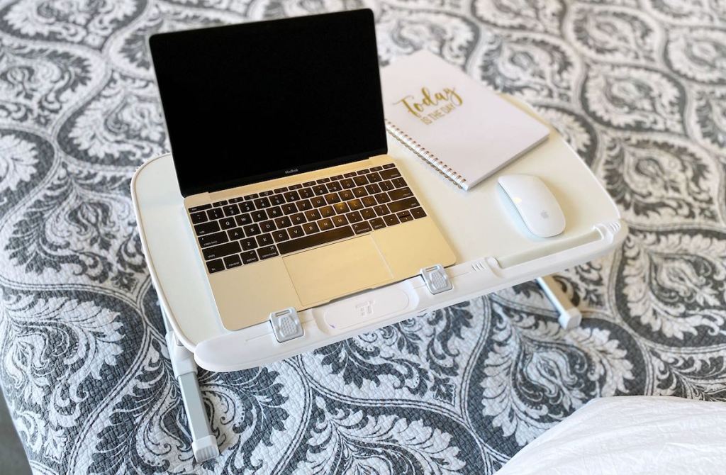laptop on white desk sitting on paisley blanket