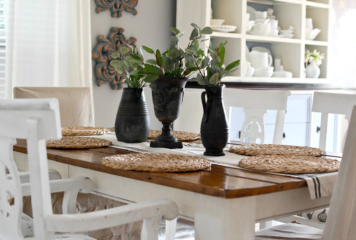 dining table with black spray paint vases and greenery