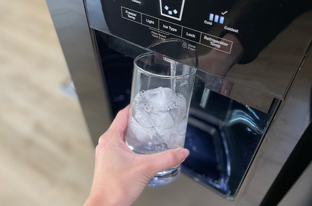 filling a glass of water from the refrigerator