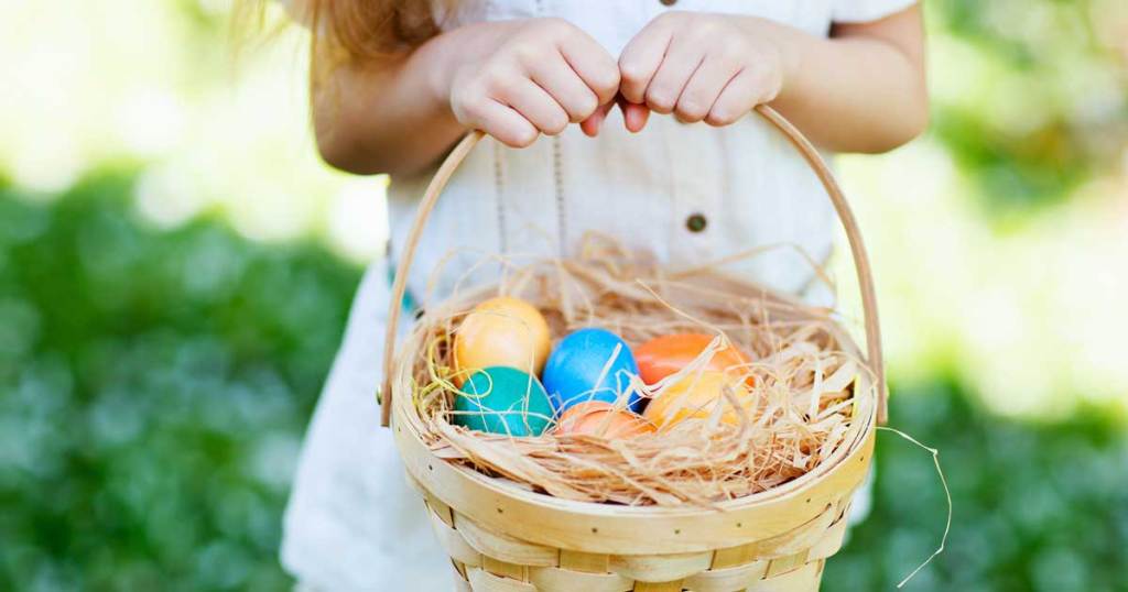 girl holding easter basket with colorful eggs