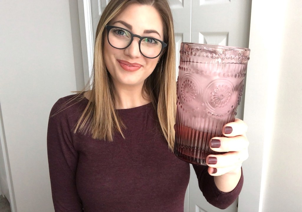 woman holding pink purple drinking glass with ice water