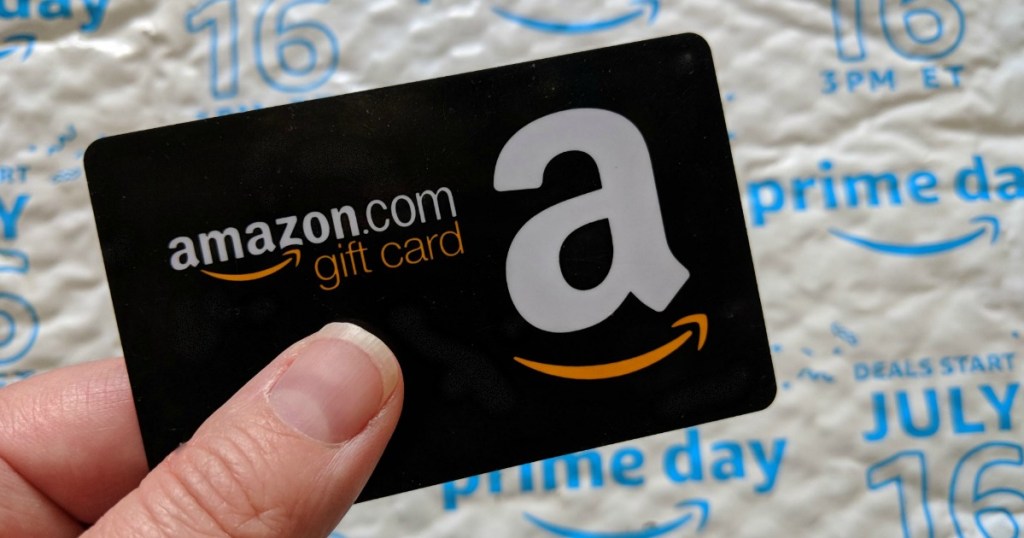 Womans hand holding an amazon gift card 