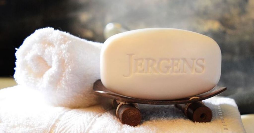 bar of soap on soap dish with rolled up washcloth next to it 