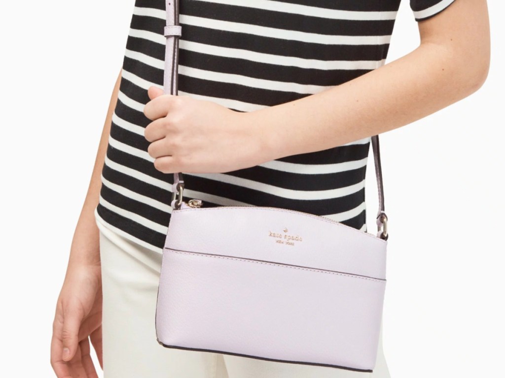 woman in stripe shirt carrying kate spade light purple bag