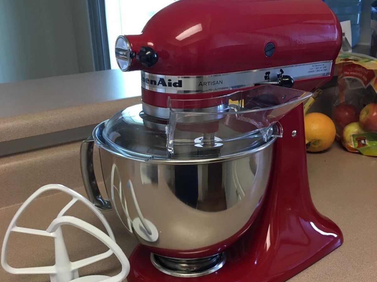 kitchenaid stand mixer with stainless steel bowl and mixer attachment on countertop