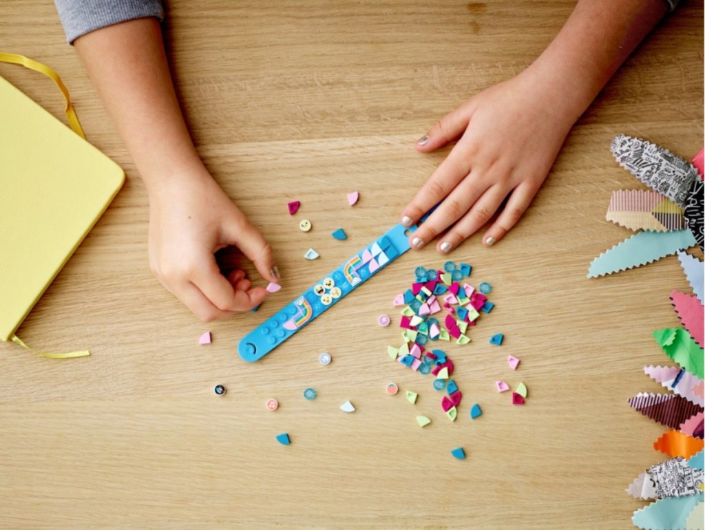 child adding LEGO DOTS to a bracelet