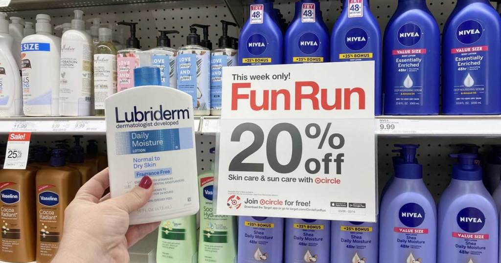 hand holding a bottle of lubriderm lotion next to promotional sign in store