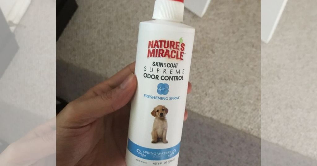 human hand holding bottle of Nature's Miracle Spray