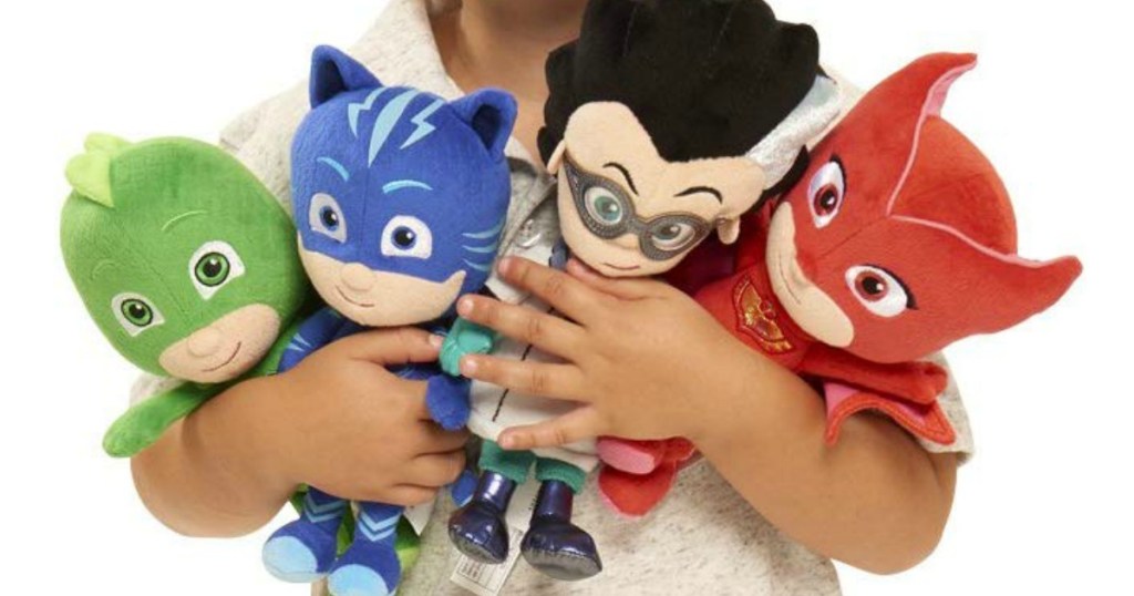 child holding plush pj masks toys