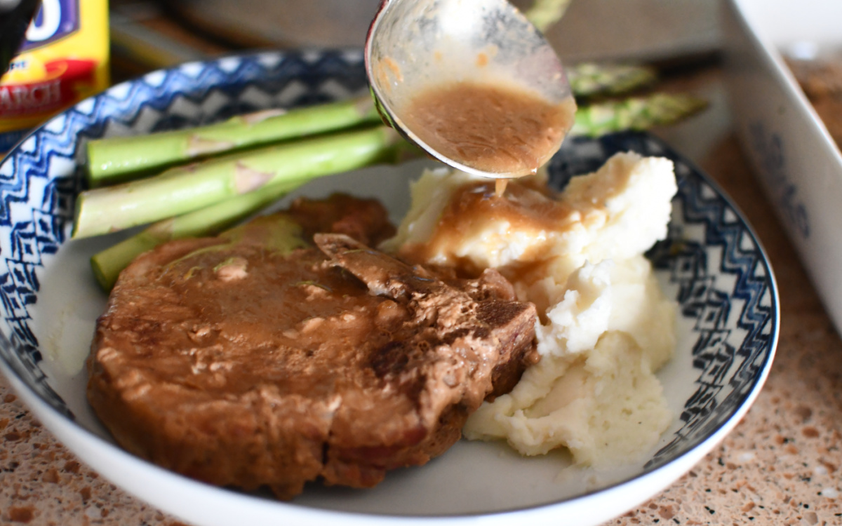 pouring gravy on top of mashed potatoes