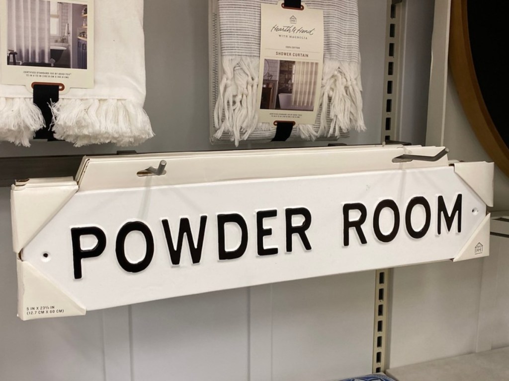 white sign with black letters that saying "Powder Room"