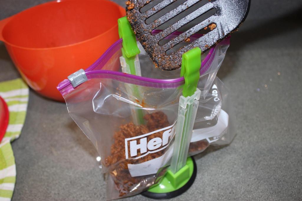 putting taco meat in bag with baggy rack holding it up