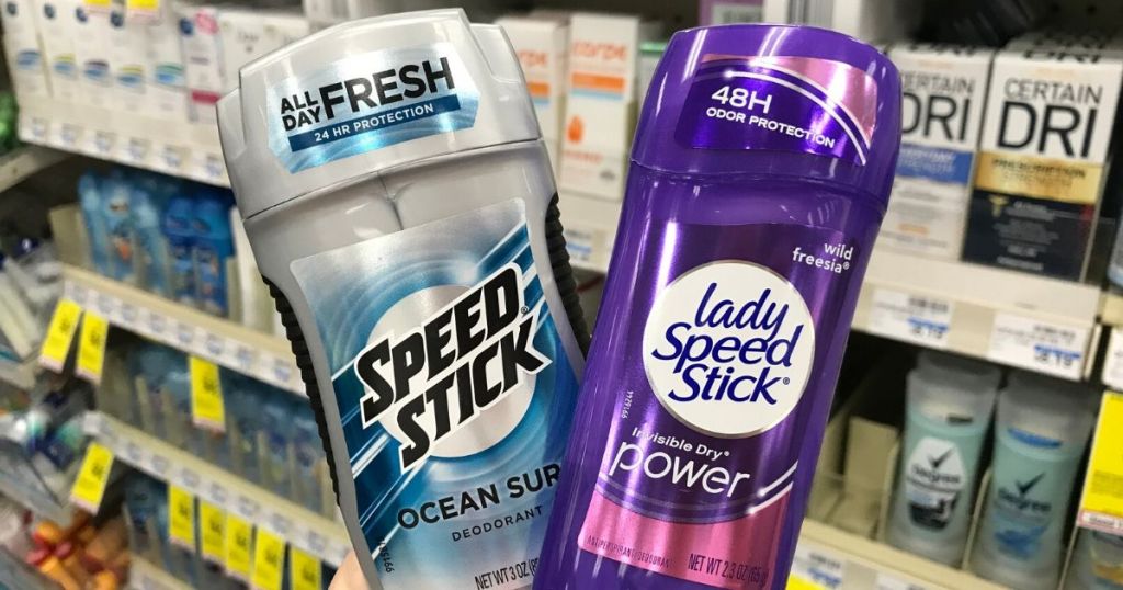 womans hand holding men's and woman's deodorant at the store