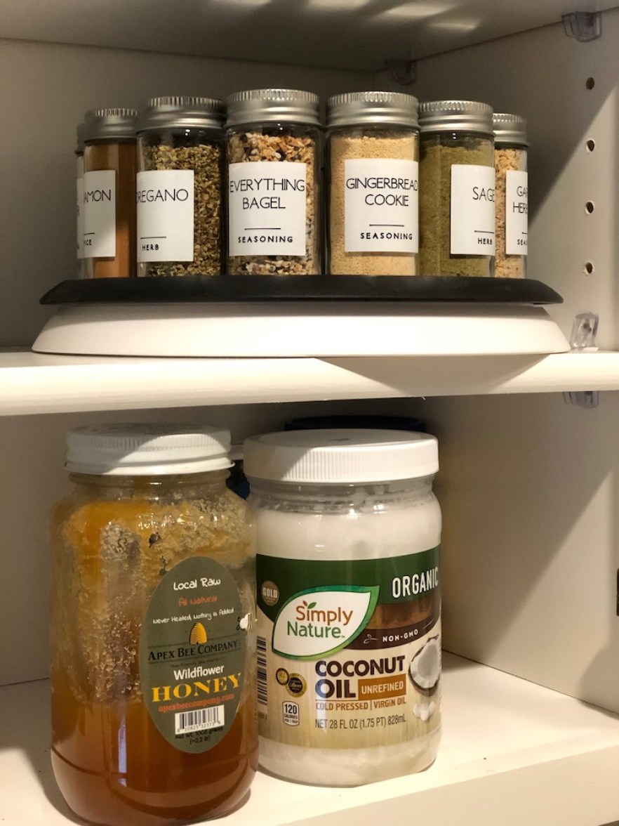spice jars labeled in pantry with containers of honey and coconut oil 
