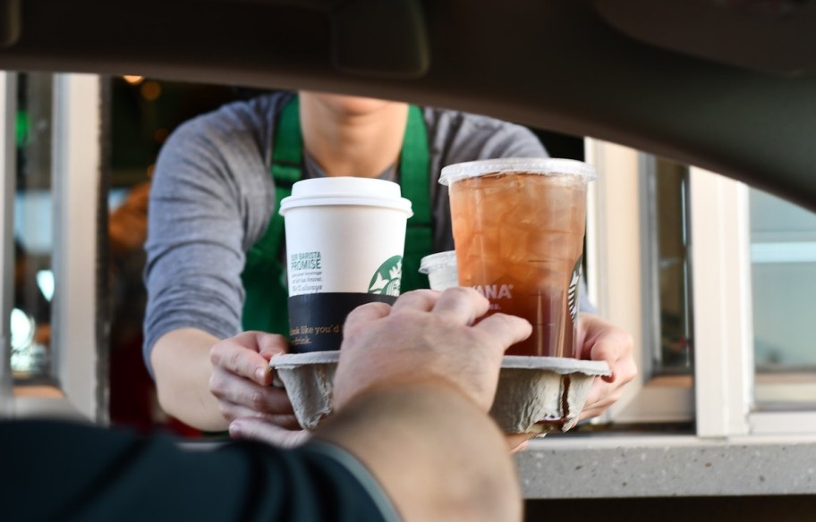 man getting Starbucks order at Drive-thru