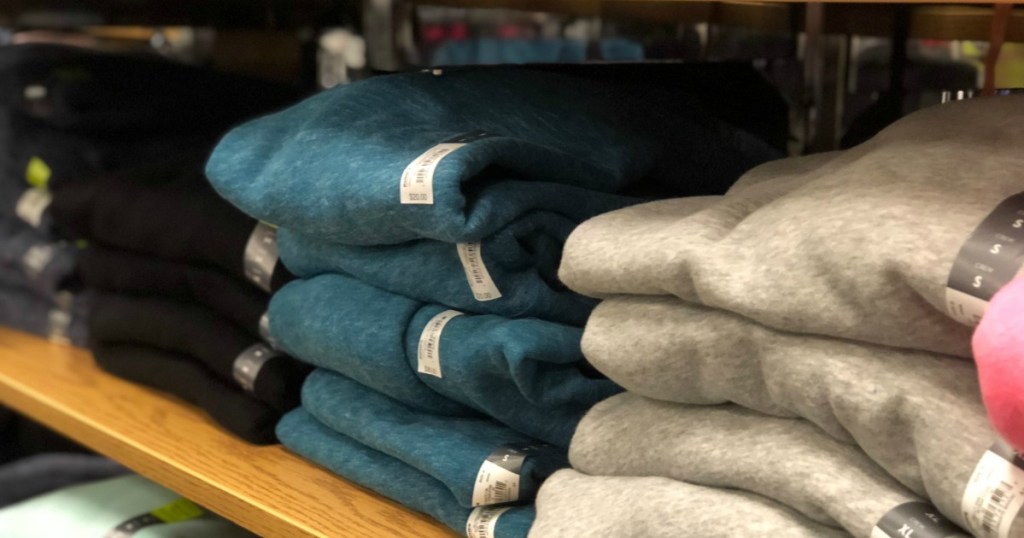 stacks of hoodies on a store shelf