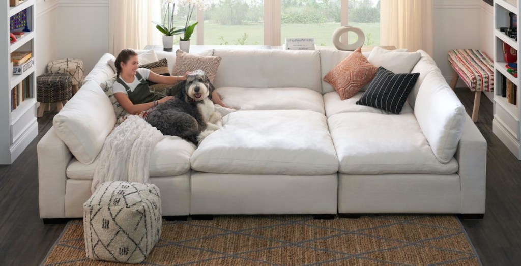 girl and dog sitting on huge white sectional sofa