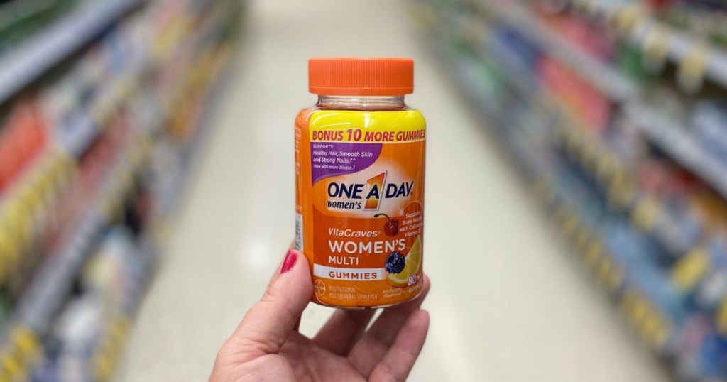 hand holding women's vitamins in a store