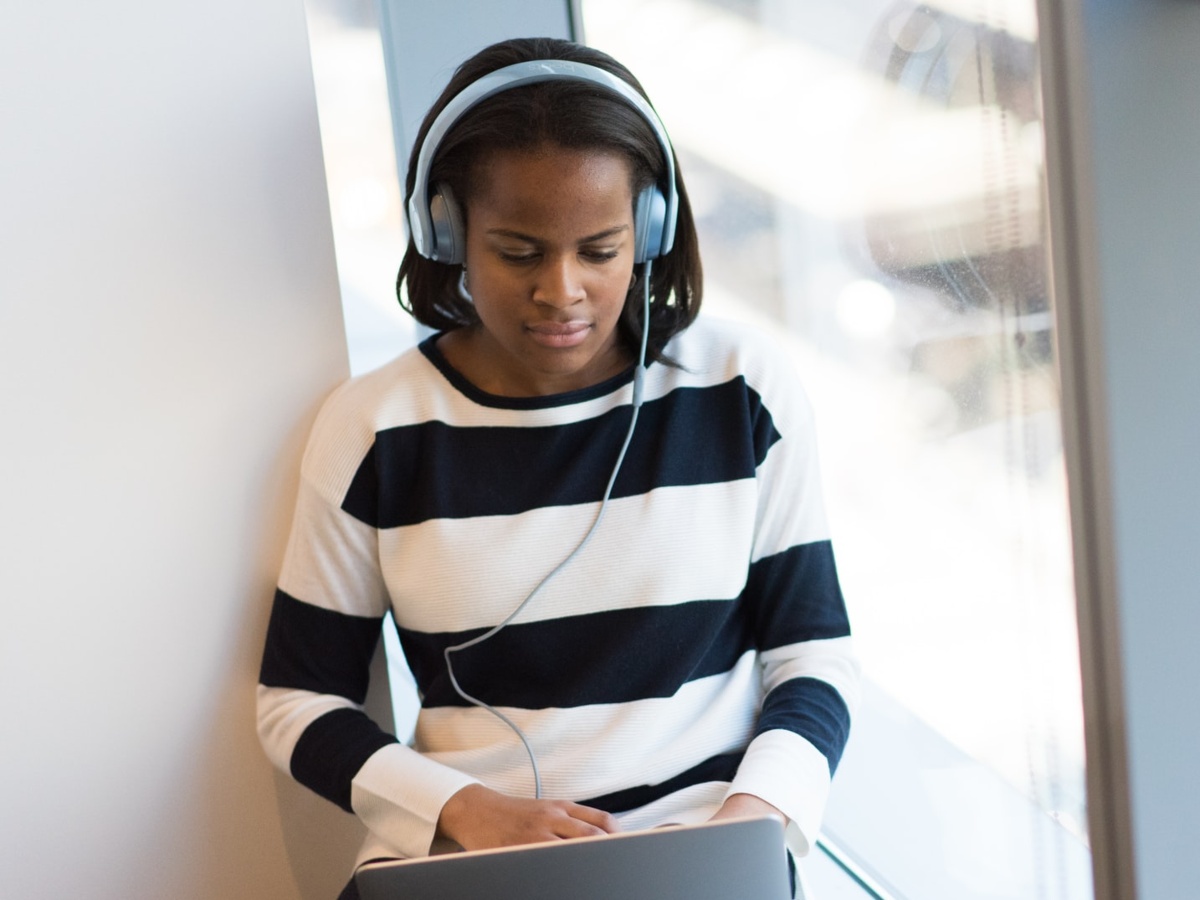 Woman wearing headphones using laptop