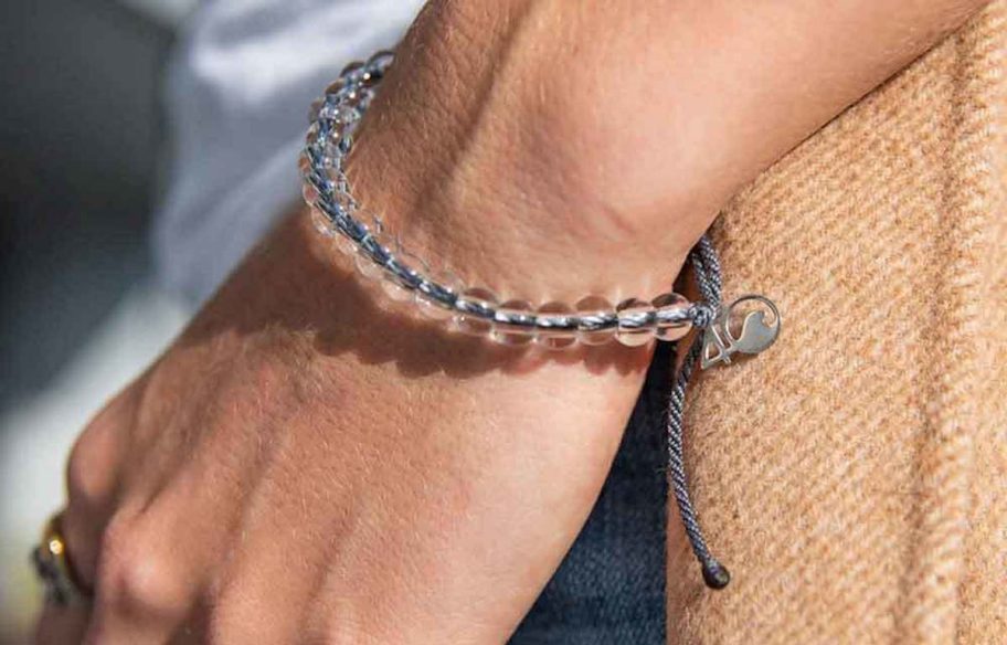 close up of persons hand wearing a gray and plastic bubble bracelet on wrist for earth day