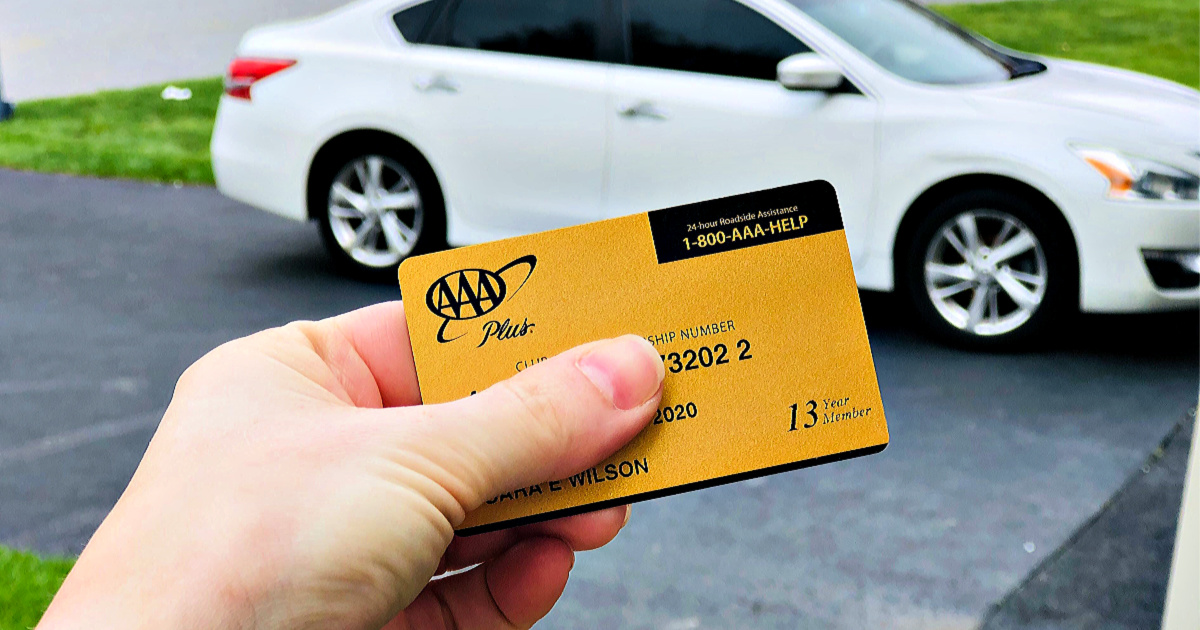 AAA Gold Membership in person's hand in front of white car which was the cheapest car rental