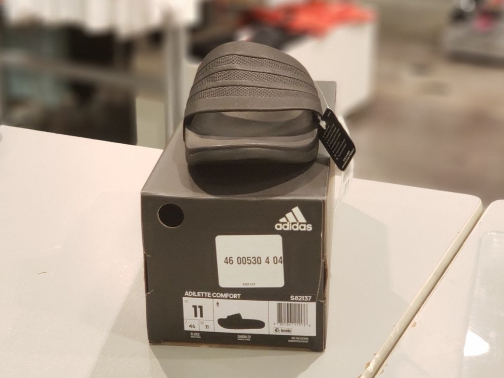 black pair of Adidas ADILETTE CLOUDFOAM SLIDE SANDAL on box