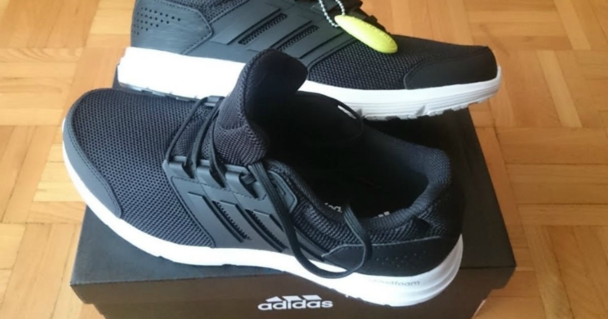 Two men's adidas brand shoes on a shoe box