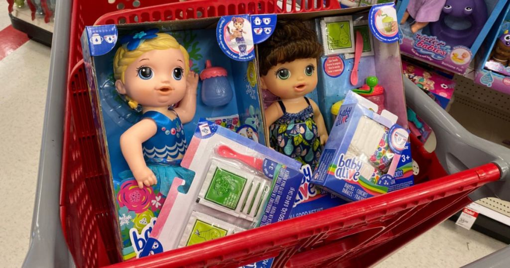 two baby alive dolls and accessories in cart at target