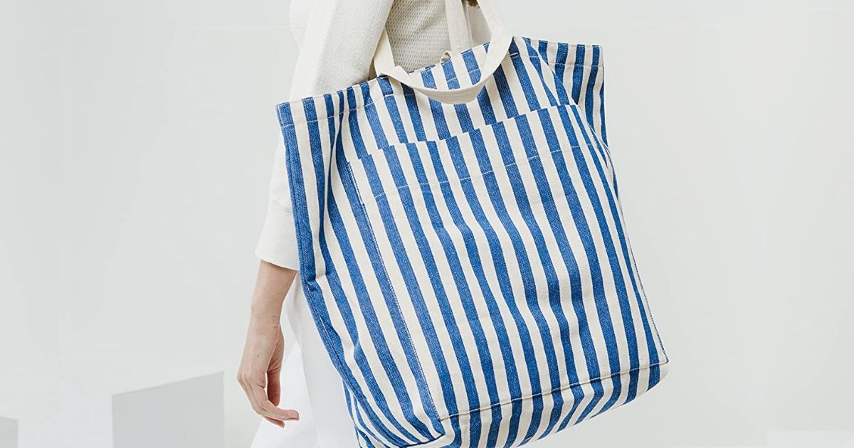 Woman holding oversized canvas tote bag over her shoulder 